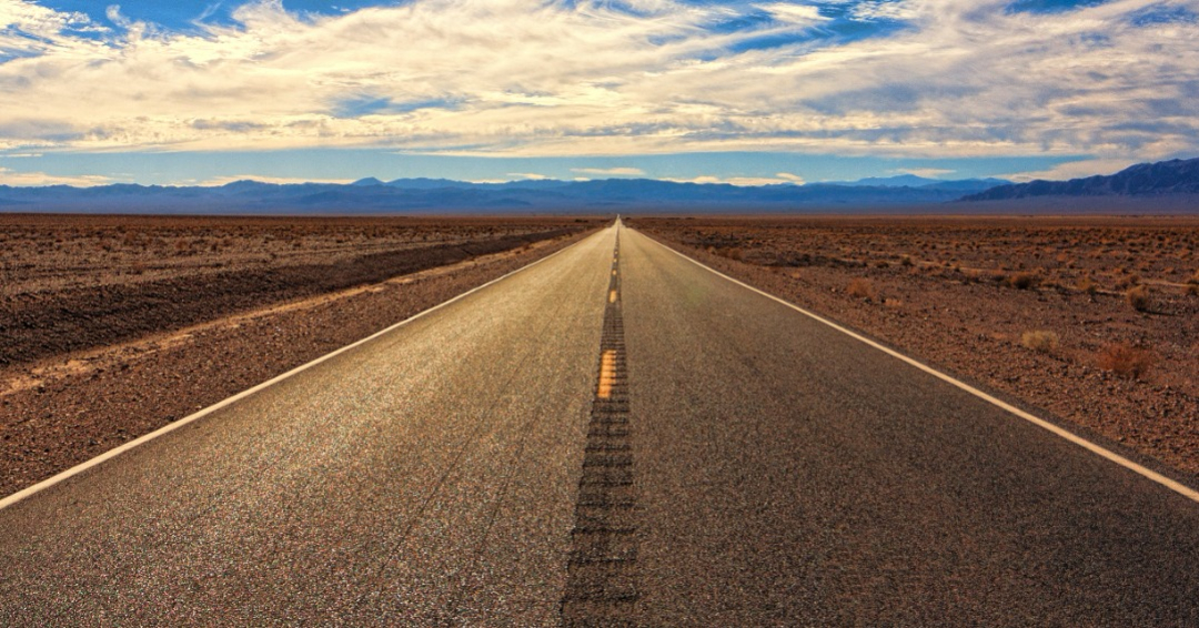 
		Photo of a road dissapearing in to the horizon in the desert		